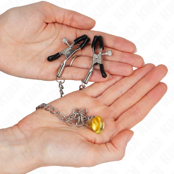 Δύο τσιμπιδάκια θηλών Kink Nipple Grip που ενώνονται με αλυσίδα με ένα χρυσό κουδουνάκι